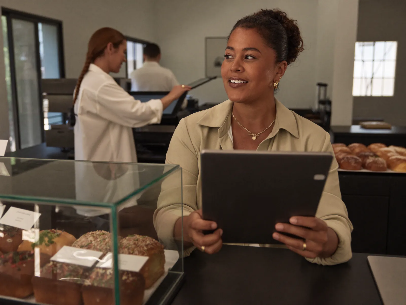 Dueña de una panadería revisa su negocio desde una tablet